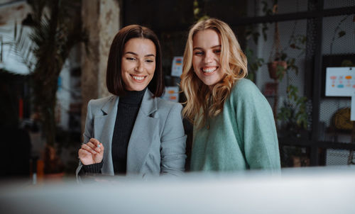 Portrait of happy young businesswomen working at office space