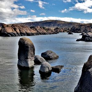 Scenic view of rock formation in water against sky