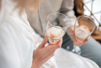 Midsection of couple holding champagne