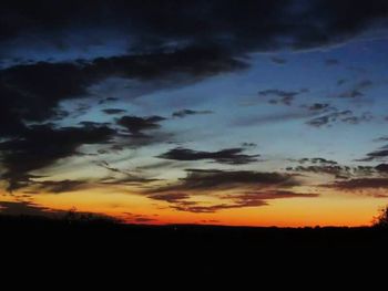 Silhouette of landscape against cloudy sky