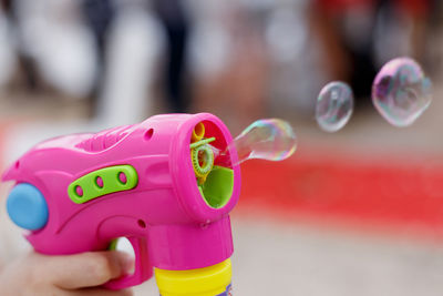 Cropped hand of child playing with bubble wand