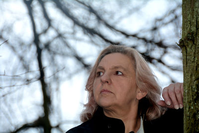 Portrait of woman looking at tree during winter