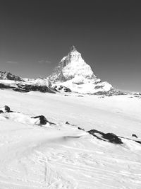 Scenic view of snow covered mountain against cloudy sky