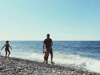 Full length of man on beach against clear sky