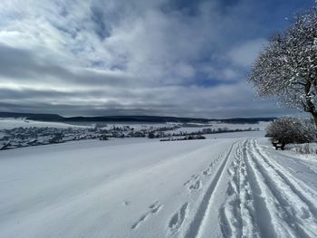 Scenic view of snow covered land against sky