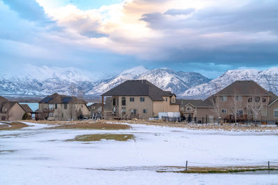 Houses by snowcapped mountains against sky