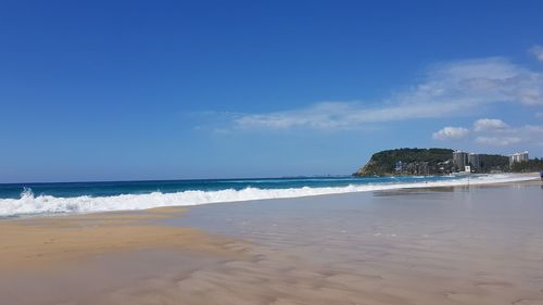 Scenic view of beach against blue sky