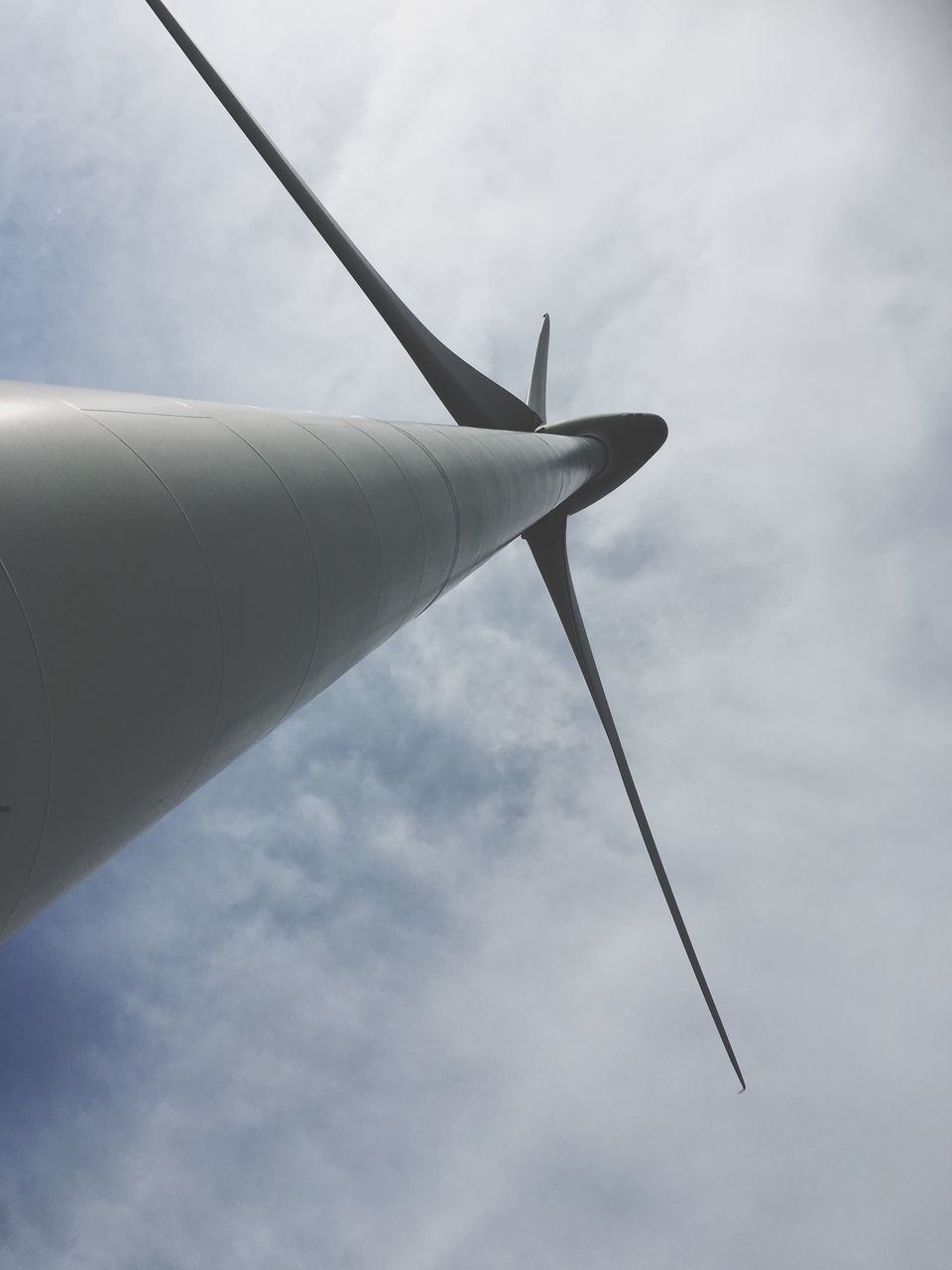 low angle view, sky, cloud - sky, airplane, flying, cloud, air vehicle, part of, day, cloudy, outdoors, transportation, no people, environmental conservation, mode of transport, alternative energy, cropped, fuel and power generation, windmill, metal