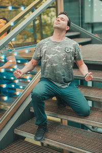 Thoughtful man clenching fists on steps 