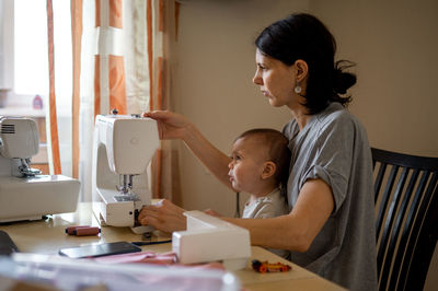 Side view of young woman working at home