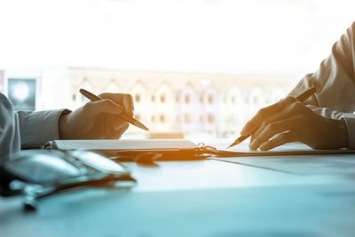 Cropped image of businessmen discussing at desk