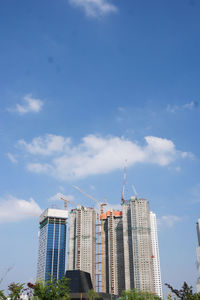 Low angle view of modern buildings against blue sky