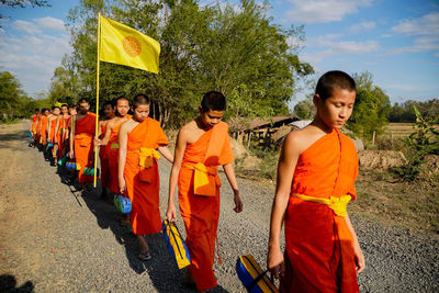 People standing by road against sky