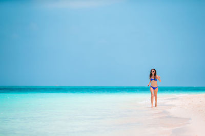 Full length of young woman standing on beach