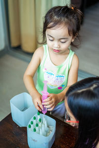 Child injecting organic fertilizer into small containers. fine motor skills activities for kids.