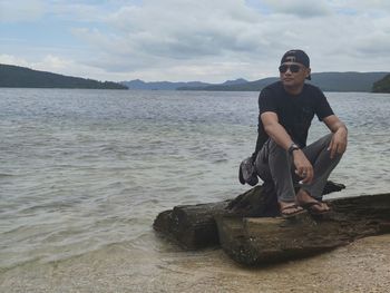 Portrait of young man in sea against sky