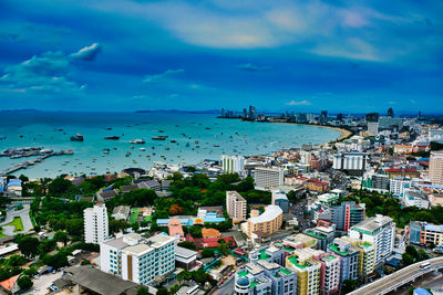 High angle view of townscape by sea against blue sky