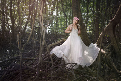 Midsection of woman with umbrella in forest