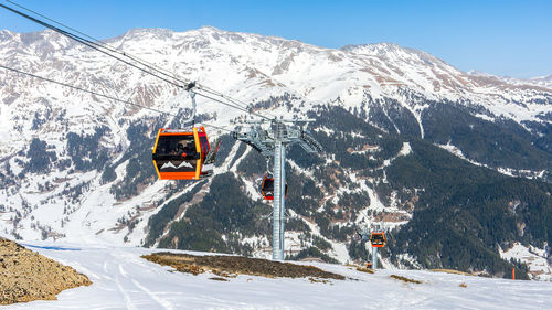 Overhead cable car on snowcapped mountains against sky