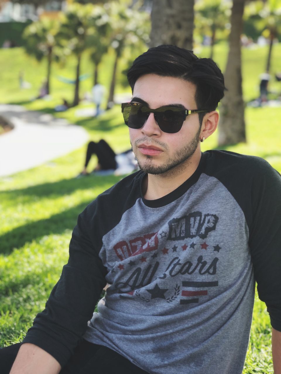 sunglasses, glasses, real people, young men, young adult, one person, casual clothing, front view, focus on foreground, lifestyles, day, fashion, plant, portrait, leisure activity, nature, grass, standing, outdoors