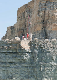 Low angle view of people on rock formation