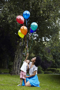 Mother with son holding bunch of balloons