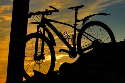 Silhouette of bicycle against sky during sunset