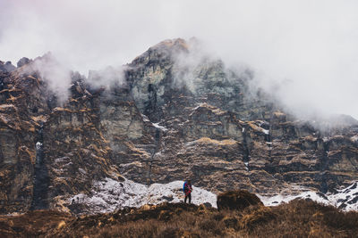 Man standing against mountain during foggy weather