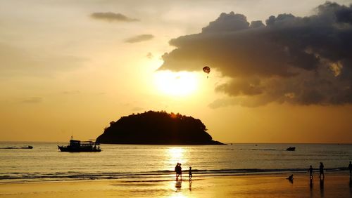 Silhouette person on beach against sky during sunset