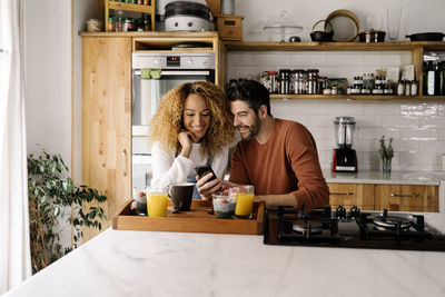 Man and woman having food in kitchen