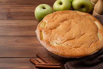 Traditional charlotte apple pie charlotte on wooden table with fresh apple and cinnamon