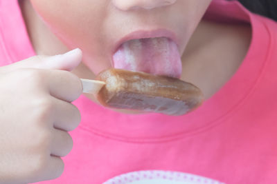 Asian little girl eating ice cream stick