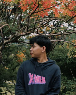 Young man looking away in forest