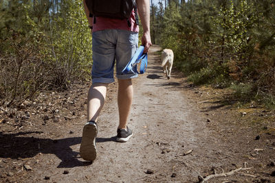 Rear view of woman walking with dog on street