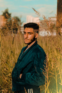 Portrait of young man standing on field