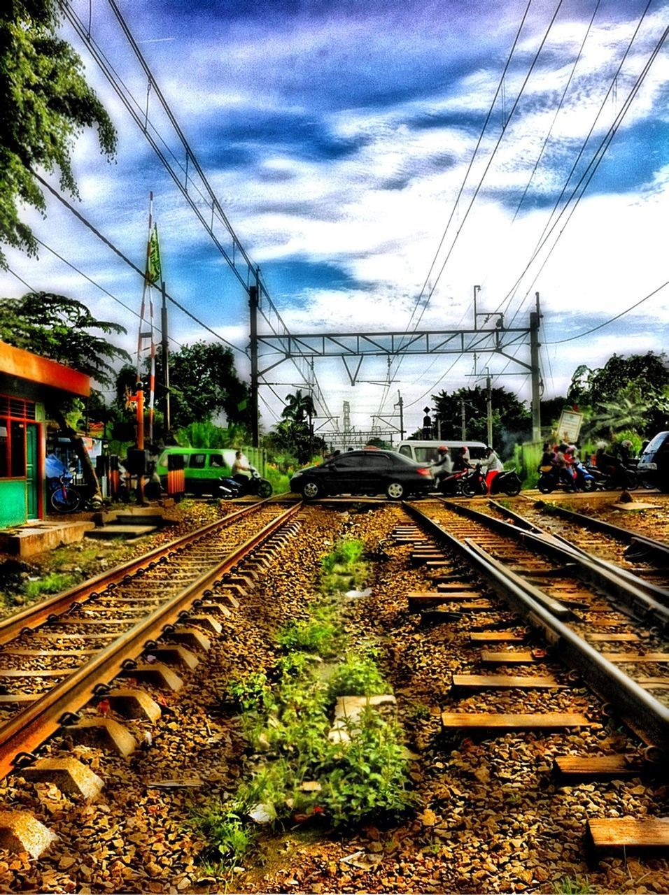 railroad track, rail transportation, transportation, public transportation, power line, electricity pylon, sky, railroad station platform, railroad station, railway track, power supply, electricity, cloud - sky, train - vehicle, cable, diminishing perspective, tree, the way forward, vanishing point, train