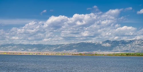 Scenic view of sea and mountains against sky