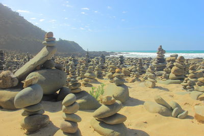 Close-up of rocks on beach against sky