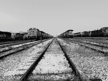 Railroad tracks on field against clear sky
