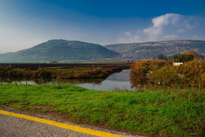 Scenic view of lake by mountains against sky