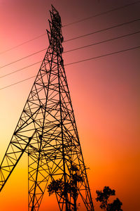 Low angle view of silhouette electricity pylon against dramatic sky