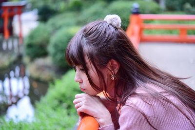 Portrait of a young woman looking away outdoors