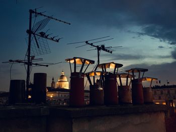 Low angle view of cranes against sky at dusk