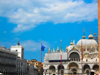Buildings in city against cloudy sky