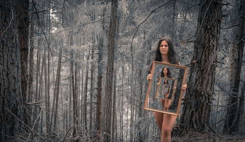 Woman on tree trunk in forest