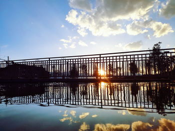 Bridge over lake against sky during sunset