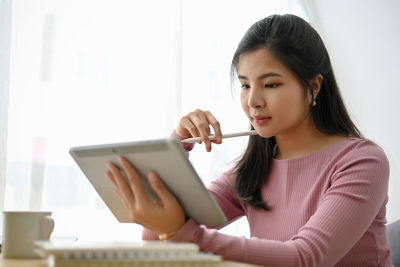 Portrait of young woman using mobile phone