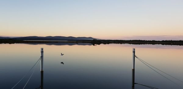 Scenic view of lake against clear sky during sunset