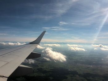Aerial view of airplane wing over clouds