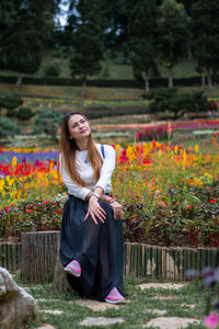 Portrait of smiling young woman against plants